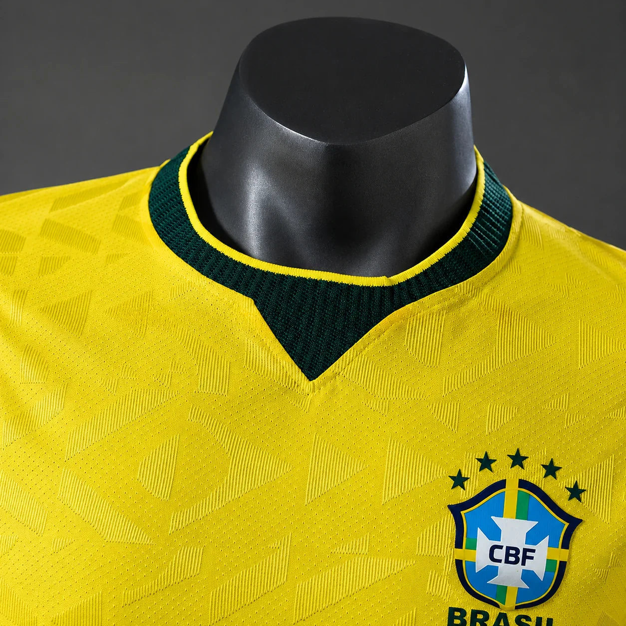 Detalhe da gola careca verde com padrão geométrico do tecido respirável da camisa do Brasil 2026 amarela versão torcedor